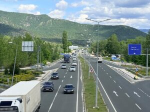 Dağlık alanda D-100’de yoğun trafik, çok şeritli yolda ilerleyen araçlar ve yol işaretleri görülüyor.