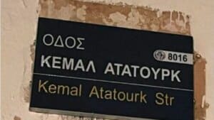 Siyah sokak tabelasında KEMAL ATATÜRK yazısı ve Kemal Atatürk Str ibaresi görünüyor.
