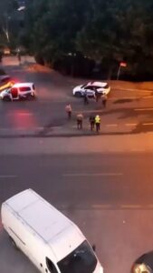 Gece vakti yol üzerinde iki araç ve aralarında motosikletliler görülüyor, polis ekipleri olay yerinde.