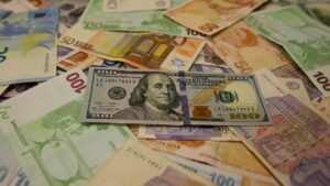 Farklı döviz banknotları arasında 100 dolarlık banknotlar yer alıyor.