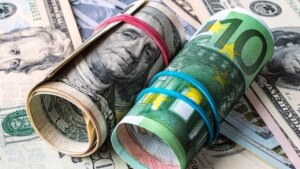 Yeşil ve mavi desenli banknotların üzerine dolanmış kâğıt paralar ve para demeti görünüyor.