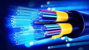 Sarı ve siyah kablo üzerinde mavi lazer ışıklarıyla uzanan fiber optik kablo görüntüsü