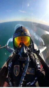 Yansıtıcı turuncu gözlüklü pilot, fırtınalı deniz üzerinde yedekli uçuşta kokpit ekranından görüntüleniyor