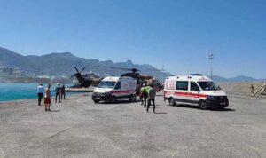 Sahil yolunda ambulans ve jandarma araçlarıyla birlikte sağlık personeli ve vatandaşlar.