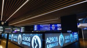 Borsa İstanbul elektronik panolarında hisse fiyatları ve grafiklerin göründüğü borsa ekranları.