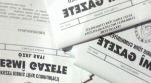 Gazete sayfaları arasında üst üste duran Türkçe metinli baskılar ve büyük başlıklar görülüyor.